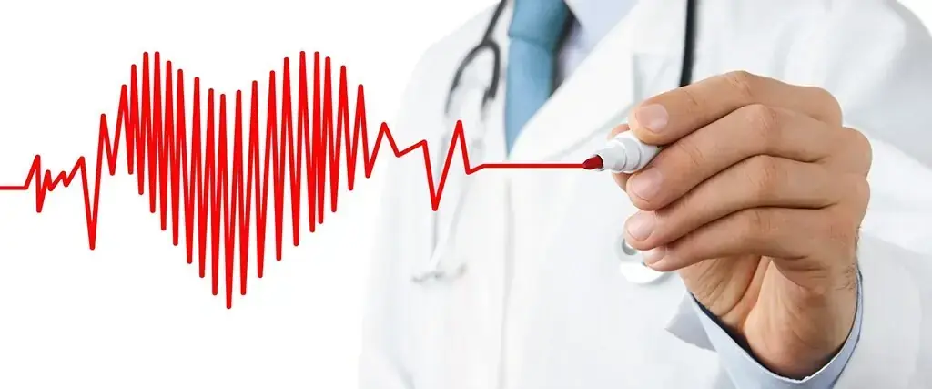 Una mano disegna un tracciato elettrocardiografico a forma di cuore