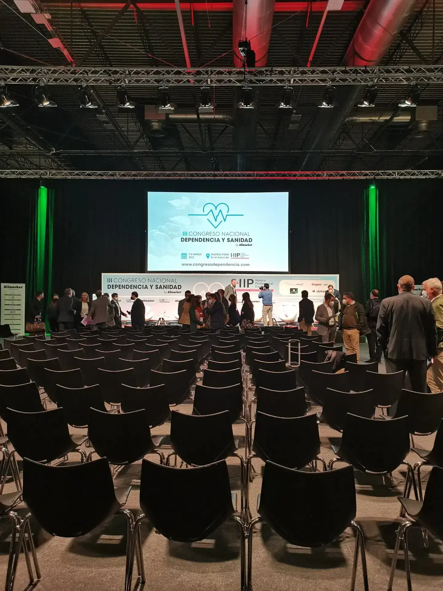 Conference hall with chairs arranged in front of the lit stage